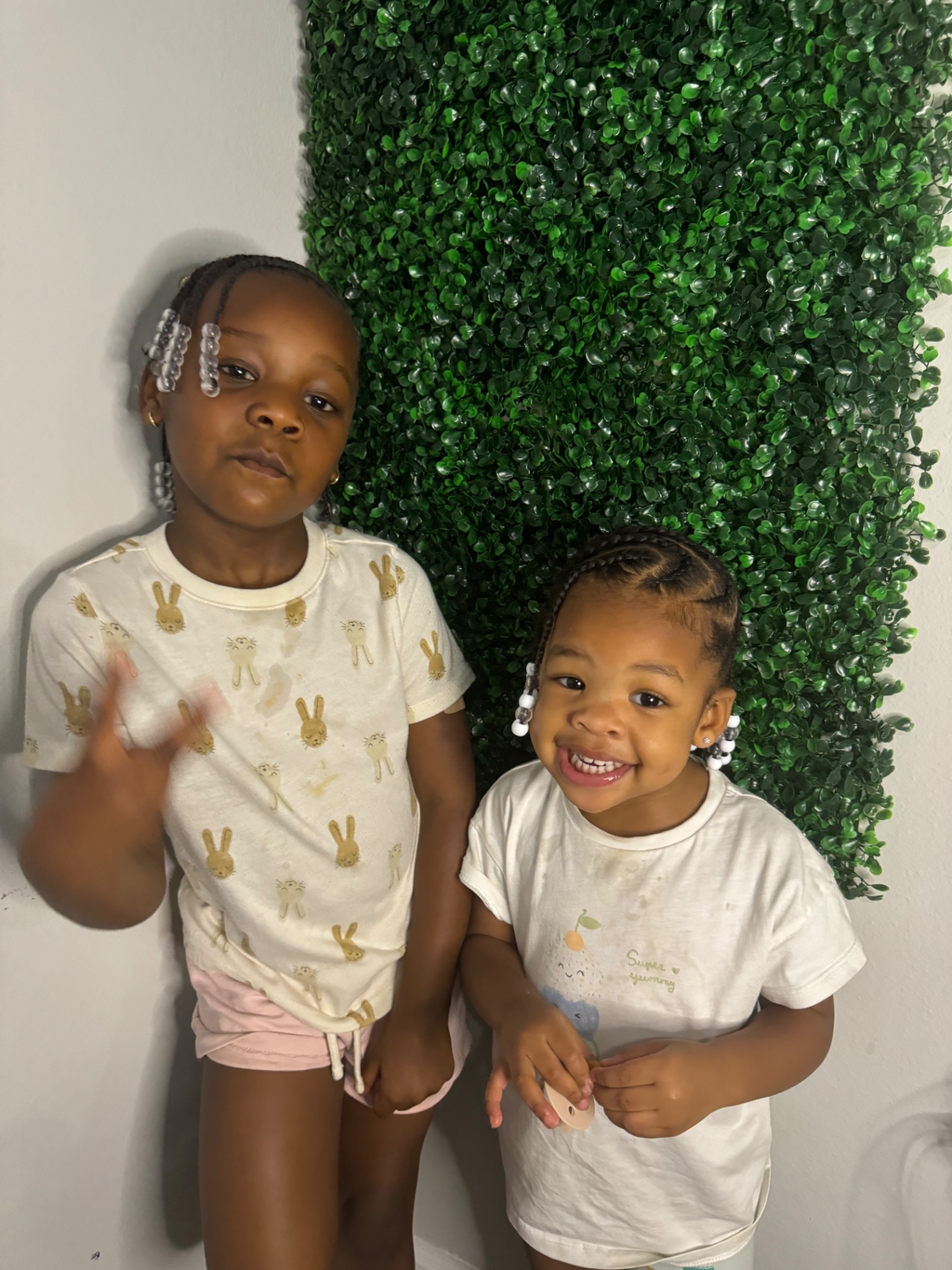 Two children showing braided styles with beads