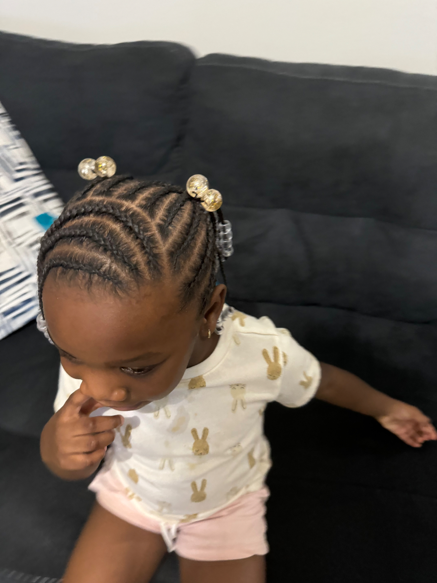 Toddler wearing feed-in braids with gold hair beads