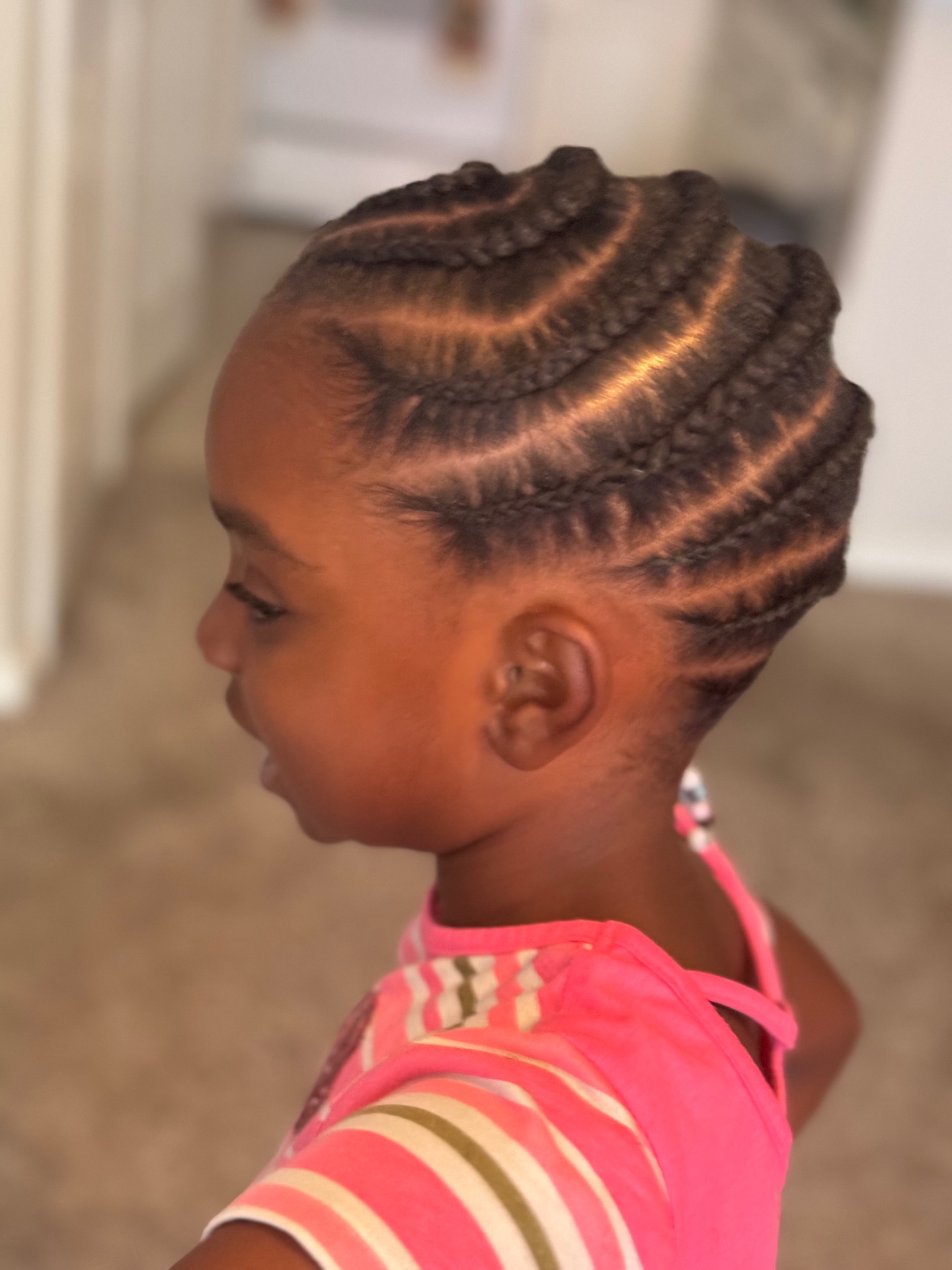 Child wearing curved cornrow design, side view